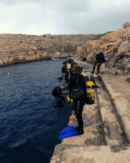 woman does scuba giant stride off stairs in malta