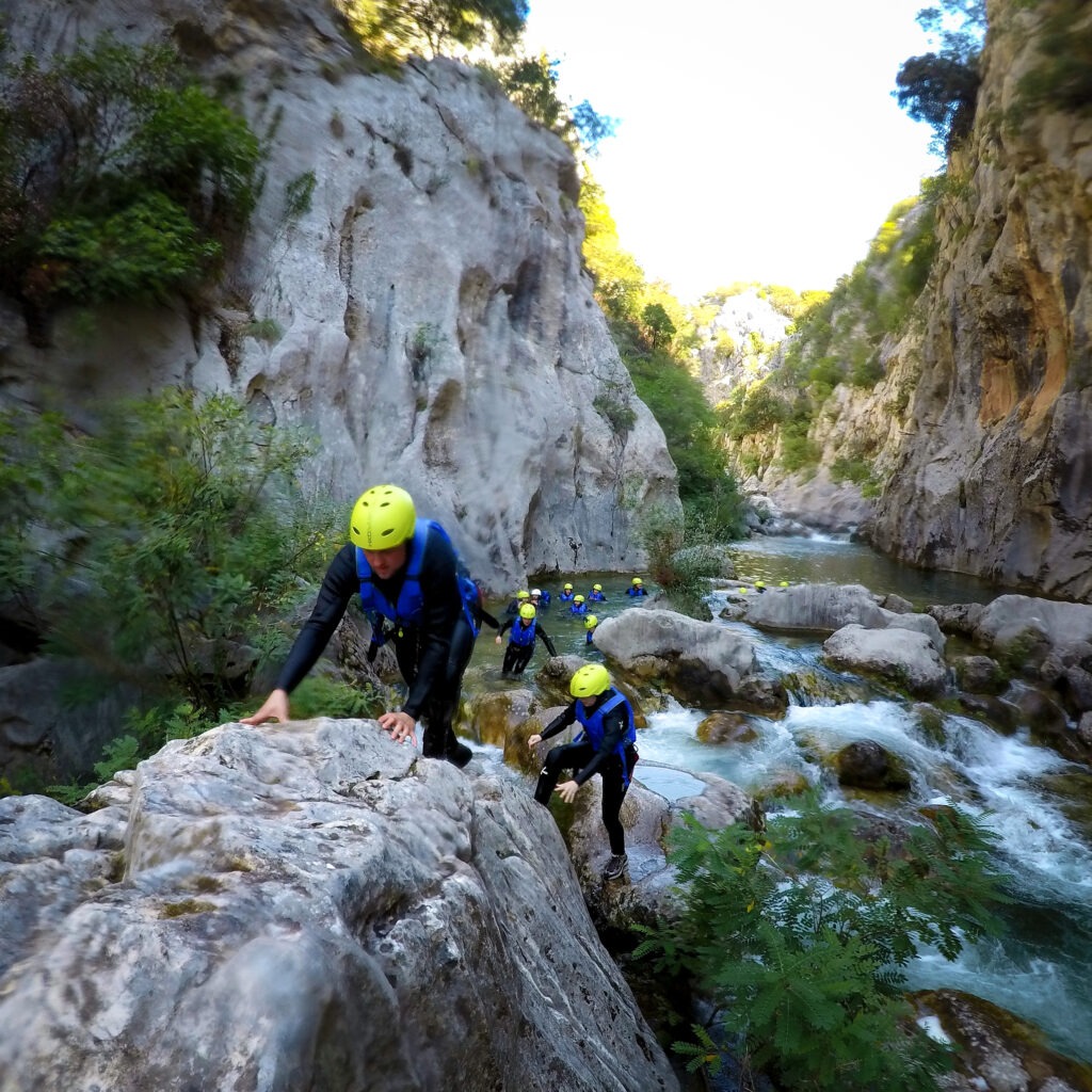 climbing over rocks in the river cetina in croatia canyoning group