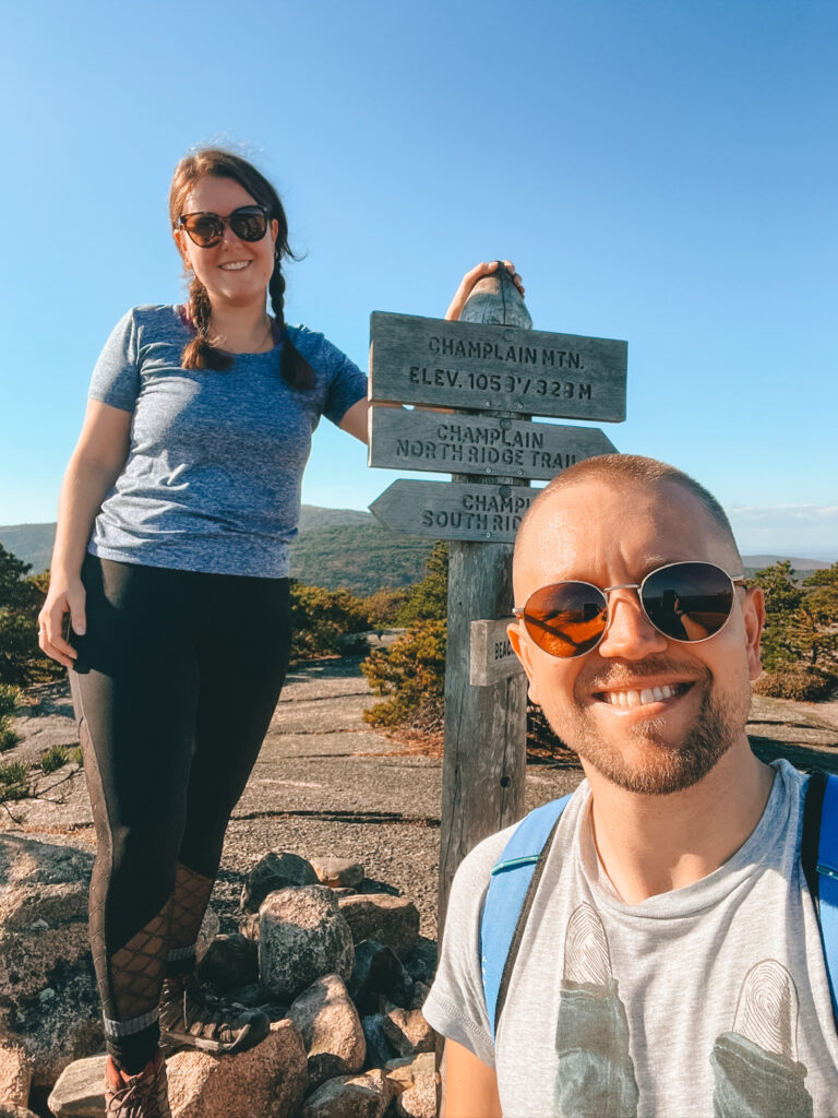 hiking couple at the champlain mountain summit sign acadia